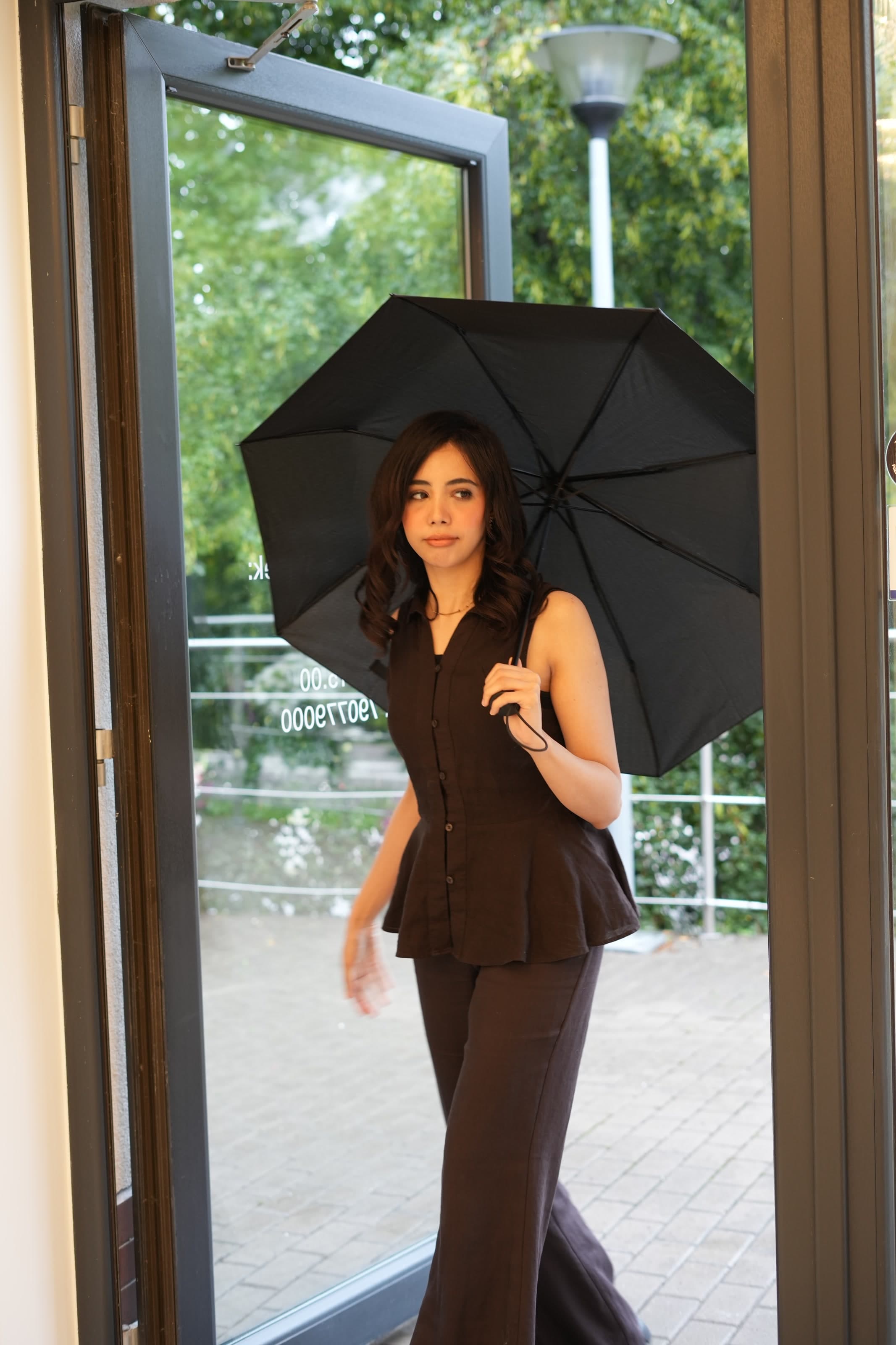 Client entering the salon with a black umbrella.