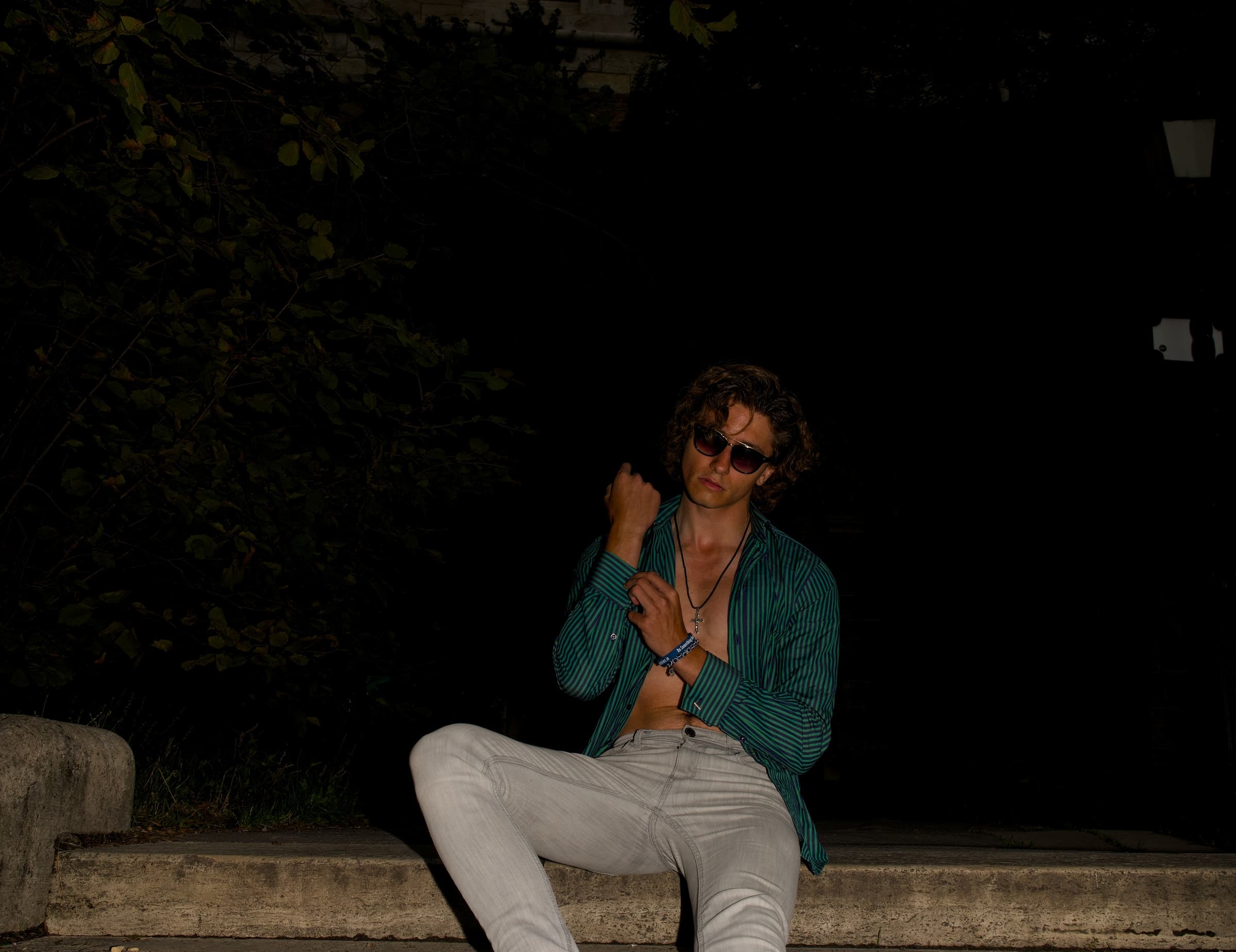 Simon Miotk in sunglasses and a green striped shirt on the steps in Budapest